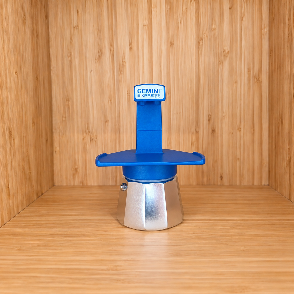 A blue Gemini Express Moka pot centered on a light wood grain surface against a matching wood grain background.