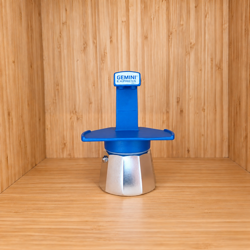 A blue Gemini Express Moka pot centered on a light wood grain surface against a matching wood grain background.