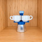 A blue Gemini Express Moka pot centered with 2 mugs on a light wood grain surface against a matching wood grain background.