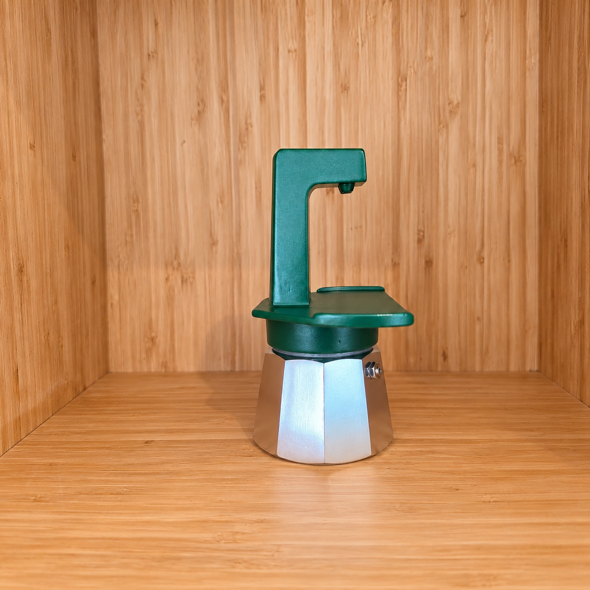 A green Gemini Express moka pot side view on a wooden surface against a wooden wall background.
